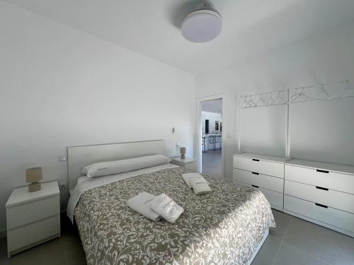 a white bedroom with a bed with two pillows on it at El Paraiso in Hozanejos