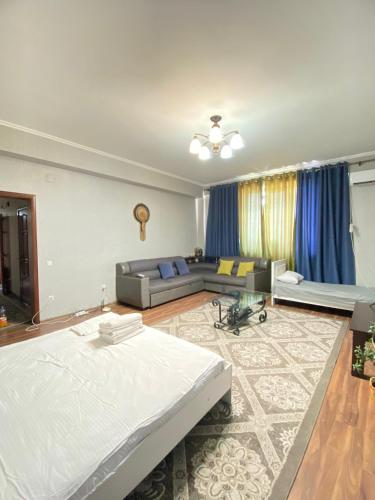 - un grand salon avec un lit et un canapé dans l'établissement Логвиненко 32, à Bishkek