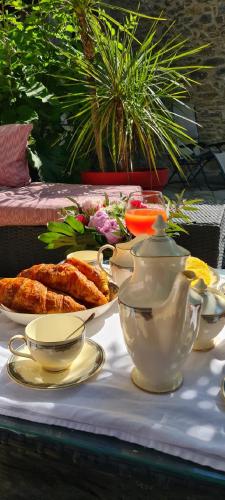 - une table avec de la vaisselle et une bouilloire dans l'établissement Villa Misanid écrin de verdure à 15mm de la cité de Carcassonne, à Mas-des-Cours