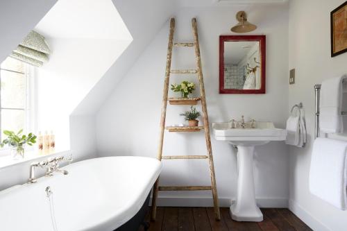 a bathroom with a white bath tub and a sink at Artist Residence Oxfordshire in Oxford