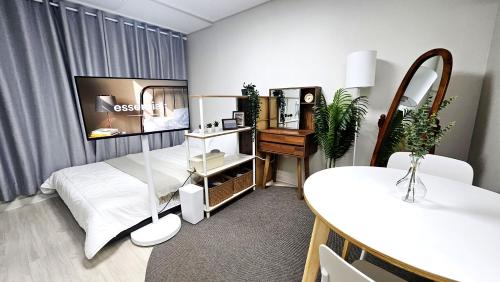 a bedroom with a bed and a table and a mirror at Maru Stay in Seoul