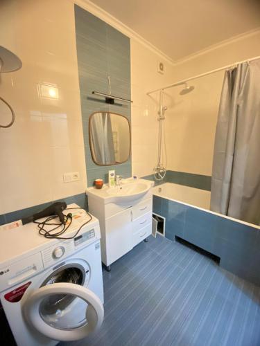 une salle de bain avec une machine à laver et un lavabo dans l'établissement Логвиненко 32, à Bishkek