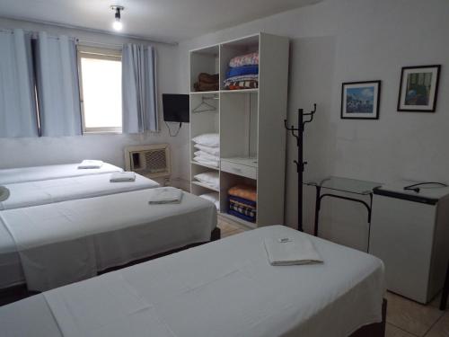 a room with two beds and a table in it at Hotel Paraiso in Santa Maria