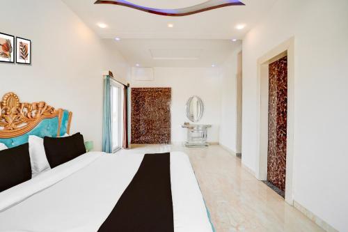 a bedroom with a large bed in a room at Hotel O The Grand Farm in Jaipur
