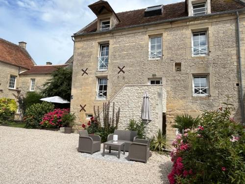 a stone building with a table and chairs in front of it at Chambres d’hôtes de l’Ancienne Auberge in Thaon