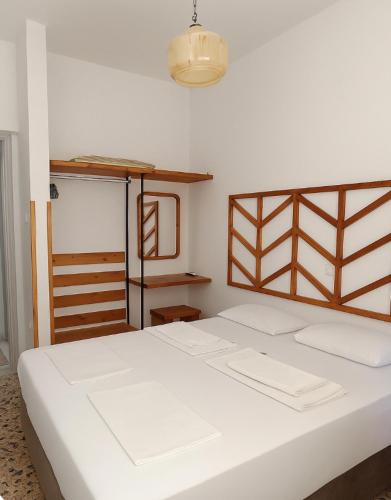 a bedroom with a large white bed and a chandelier at Hidden Treasure Unique Apartments Kokkari Samos in Samos