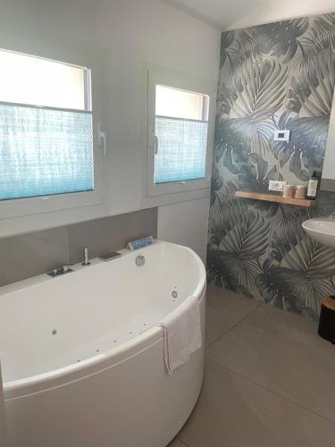 a bathroom with a bath tub and a sink at Hotel Giardino in Breno