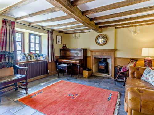 a living room with a piano and a red rug at 7 Bed in Waterhouses 81529 in Waterhouses