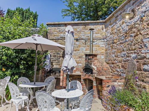 a patio with tables and chairs and an umbrella at 7 Bed in Waterhouses 81529 in Waterhouses