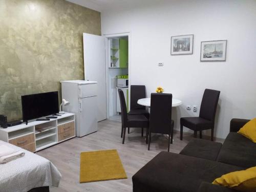 a living room with a couch and a table with chairs at Belvedere Skadarska Apartment in Belgrade