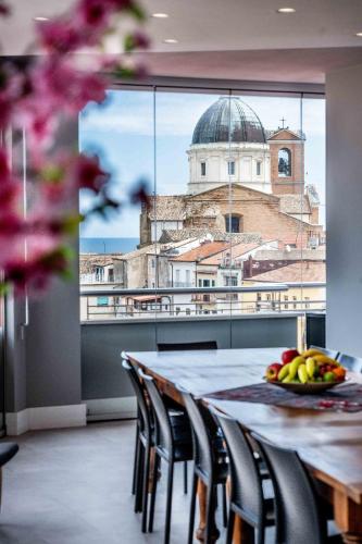 a dining room table with a view of a building at Attico vista mare con Jacuzzi - CASA LUXURY DIAMANTE in Ortona