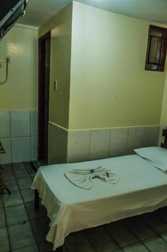 a bedroom with a white bed with a ribbon on it at Hotel Santo Antoninho in Goiânia