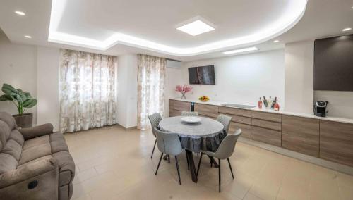 a living room with a table and chairs and a kitchen at Attico vista mare con Jacuzzi - CASA LUXURY DIAMANTE in Ortona