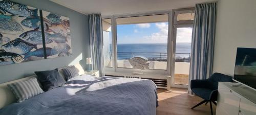 a bedroom with a bed and a large window at Himmel & Meer Suite in Timmendorfer Strand