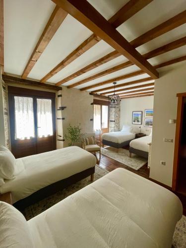 a bedroom with two beds and a living room at Casa El Colibrí in Villafranca del Bierzo
