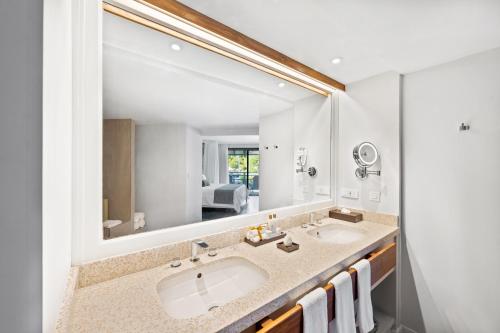a bathroom with two sinks and a large mirror at St Martin Beach Resort & Spa in Anse Marcel 