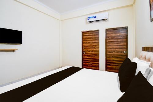 a bedroom with a bed and a flat screen tv at OYO Flagship hotel vasundhara inn in Lucknow