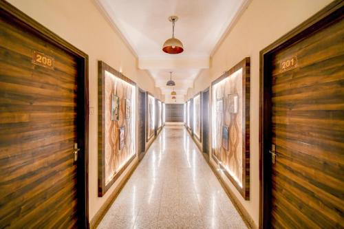 a corridor of a building with paintings on the walls at OYO Flagship hotel vasundhara inn in Lucknow