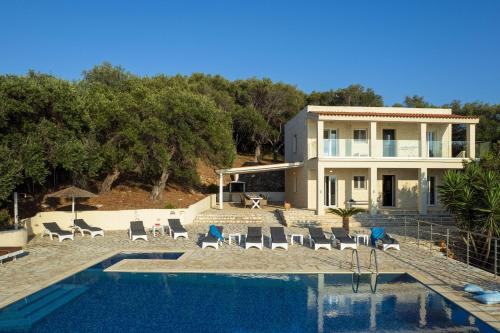 a villa with a swimming pool and a house at Beachfront Villa Seasun by PosarelliVillas in Agios Spyridon Corfu