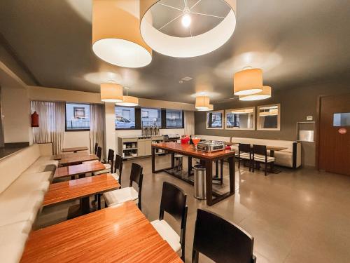 a dining room with wooden tables and chairs at Stay Hotel Porto Centro Antas in Porto