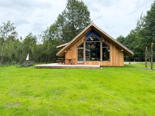 a cabin in the middle of a grass field at Dabintos slėnis in Sumiliszki