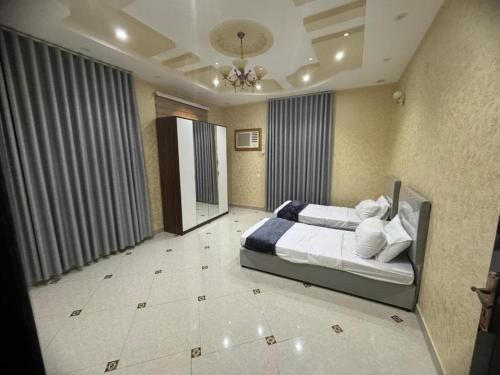a bedroom with a large bed in a room at وسام شقة كبيرة 4 غرف نوم وصالة وشرفة-بلكونة- Large apartment with 4 bedrooms, a living room and a balcony in Taif