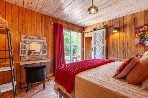 a bedroom with a bed and a chair and a window at Le Chalet Des Oliviers in Roquefort-la-Bédoule