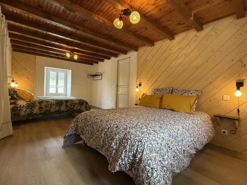 a bedroom with a large bed in a room with wooden ceilings at Gliget in Lourdios-Ichère