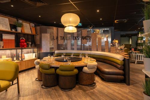 a restaurant with a table and some chairs at Novotel Bordeaux Centre Ville in Bordeaux