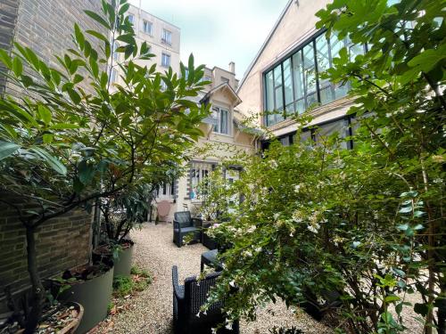 a courtyard of a building with trees and plants at Love House - Maison entière et son jardin - Rare à Paris in Paris