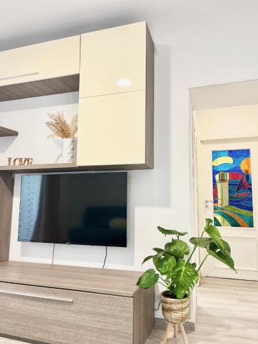 a living room with a tv and a potted plant at La Torretta Apartment in Savona