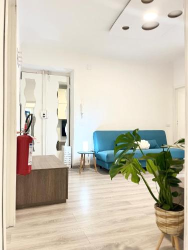 a living room with a blue couch and a plant at La Torretta Apartment in Savona