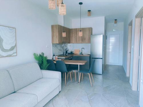 a kitchen and living room with a couch and a table at EriZen Jacuzzi suites in Keramotí