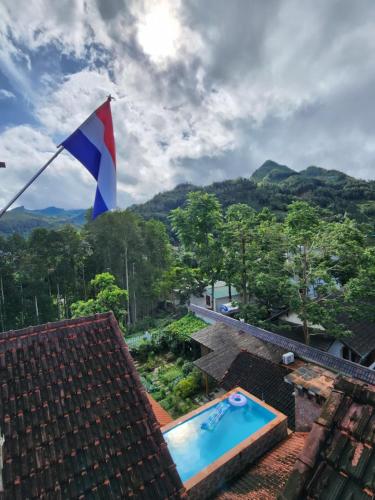 a flag on the roof of a house with a swimming pool at Huy Trung Homestay in Bắc Hà