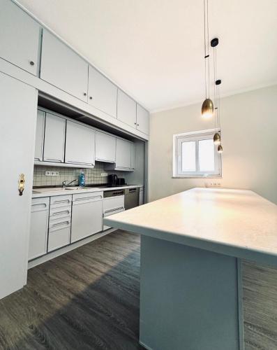 a large kitchen with white cabinets and a large island at Hotel Wissers Fehmarn in Burg auf Fehmarn