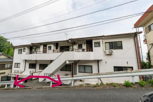 a building with a pink ribbon in front of it at Nagasaki Night View Stay 長崎絶景ステイ - Lotus長崎 in Nagasaki