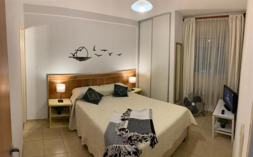 ein Schlafzimmer mit einem Bett mit Vögeln an der Wand in der Unterkunft Francia Apartment in Rosario