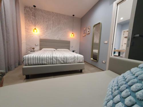 een slaapkamer met een bed in een kamer met een muur bij Playa-degli-Angeli-Appartamenti in Gabicce Mare