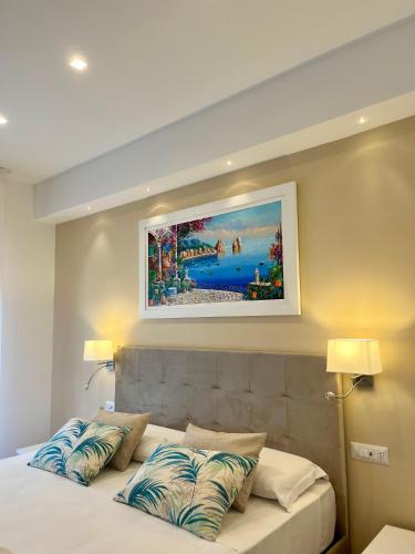a bedroom with a bed with a painting on the wall at Hotel Kali Sorrento in Sorrento