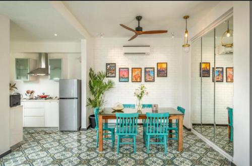 a kitchen with a table and chairs and a refrigerator at 2bhk Villa with Private Pool, Anjuna Beach Goa in Assagao