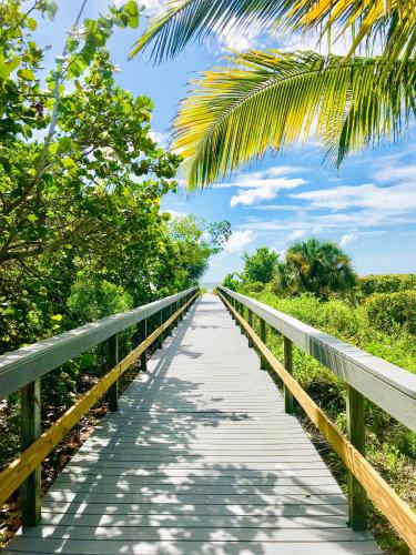 a wooden bridge with a palm tree on it at Sanibel Siesta on the Beach in Sanibel