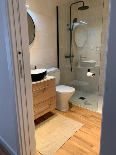 a bathroom with a toilet and a glass shower at InBerna in Peniche