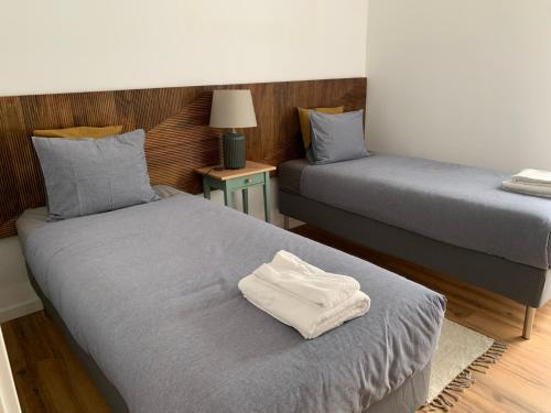 Dos camas en una habitación con una toalla blanca encima. en InBerna, en Peniche