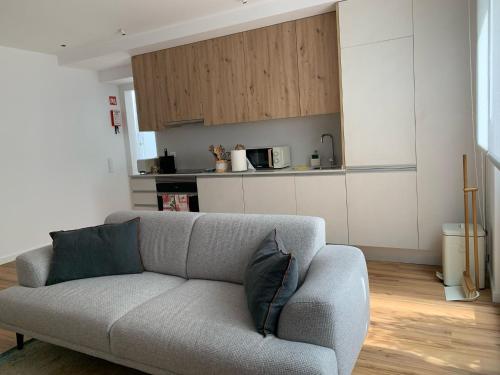 Una sala de estar con un sofá y una cocina. en InBerna, en Peniche