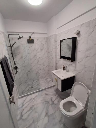 a bathroom with a shower and a toilet and a sink at Studio Andrew in Saturn
