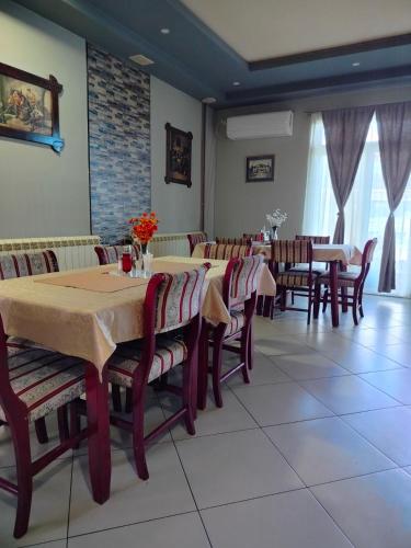 Un comedor con mesas y sillas en un restaurante. en Sobe restoran Beba, en Pljevlja