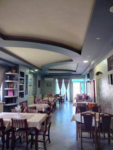 Un restaurante con mesas y sillas en una habitación. en Sobe restoran Beba, en Pljevlja