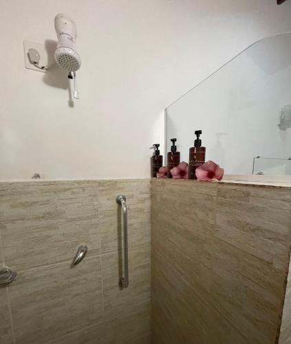a bathroom with a mirror and some bottles on a counter at Pousada Vila Icaraí in Icaraí