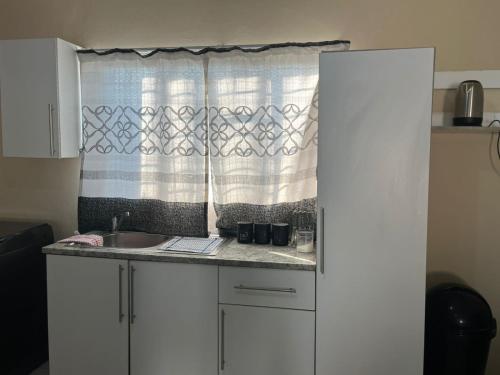 a kitchen with a sink and a window at Dee village in Mahikeng