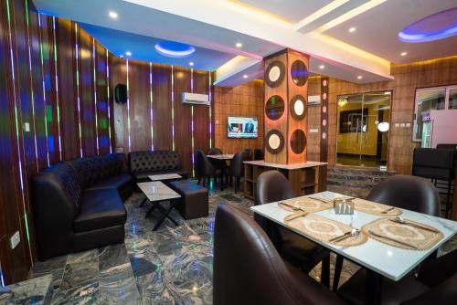 a restaurant with tables and chairs and a couch at Presken Hotels, Awolowo Way, Ikeja in Ikeja
